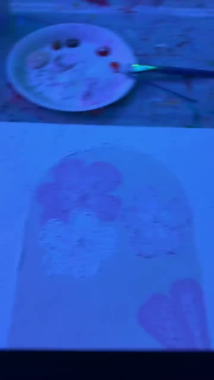 Eine Leinwand wird bei Neonlicht auf einem Abend-Mal-Event bemalt